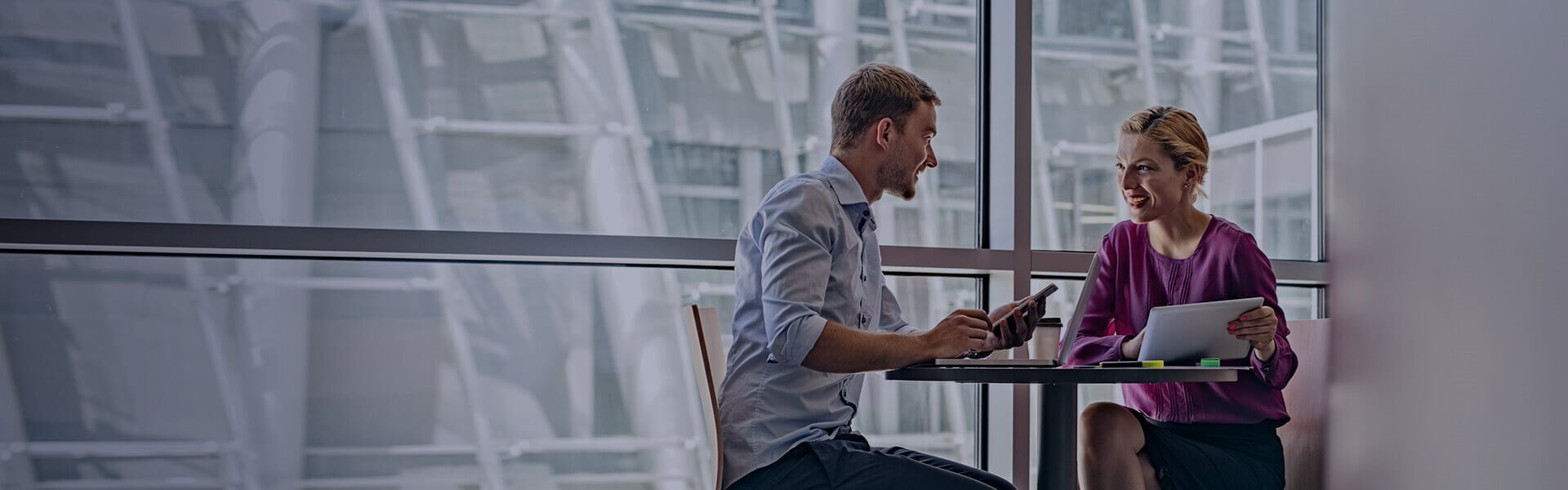 Image of two people sat at a small table having a meeting