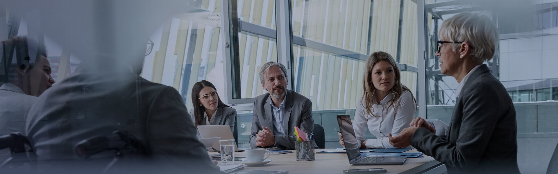 Image of people sat in a meeting room listening intently to someone speaking
