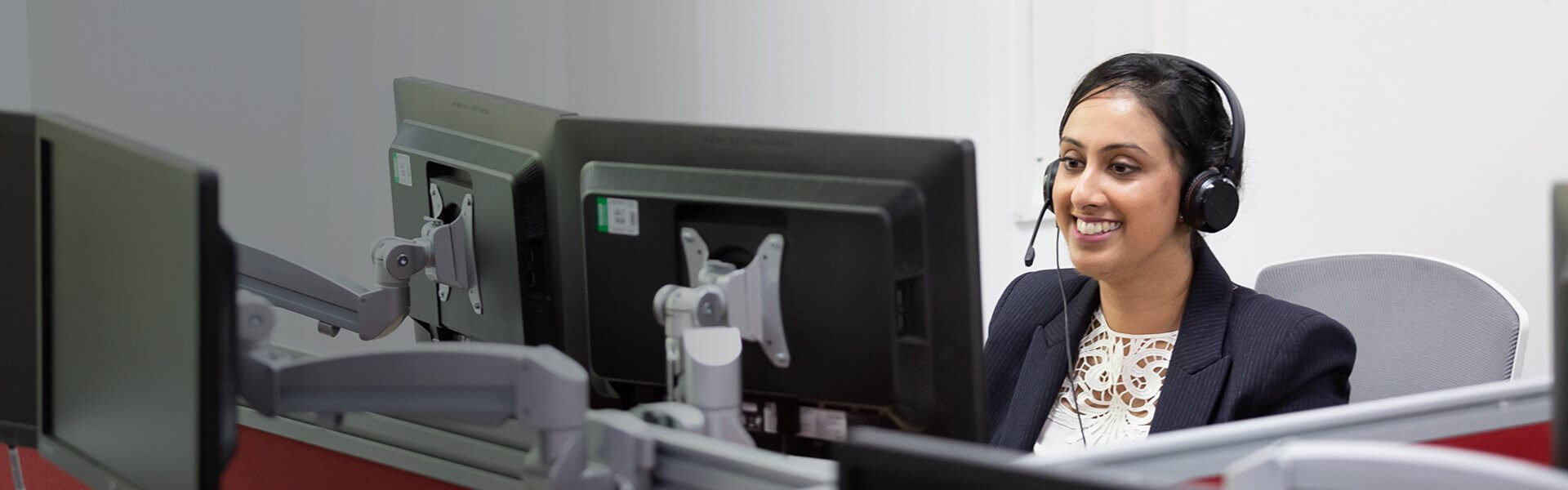 Image of someone working at a desk whilst on the phone